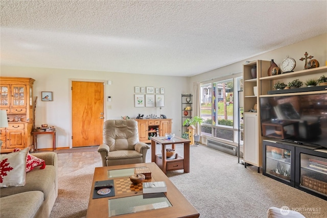 living area featuring carpet, baseboard heating, and a textured ceiling