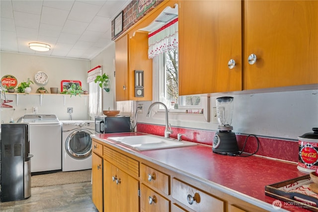 laundry room featuring laundry area, washing machine and dryer, and a sink