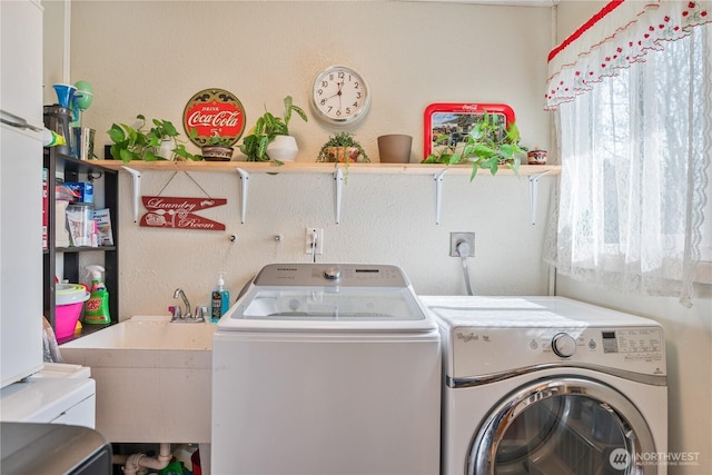 laundry area with a sink, washing machine and dryer, and laundry area