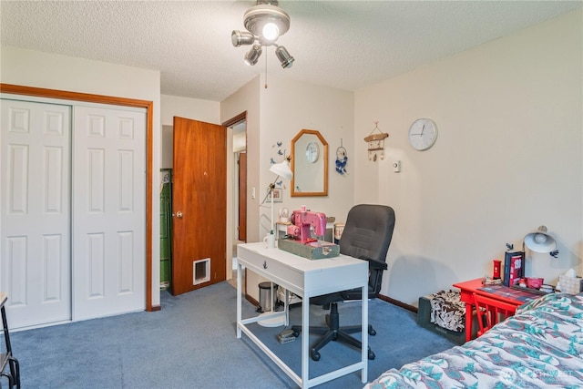 carpeted bedroom with a closet, a textured ceiling, and baseboards