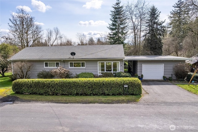 single story home featuring aphalt driveway and an attached garage