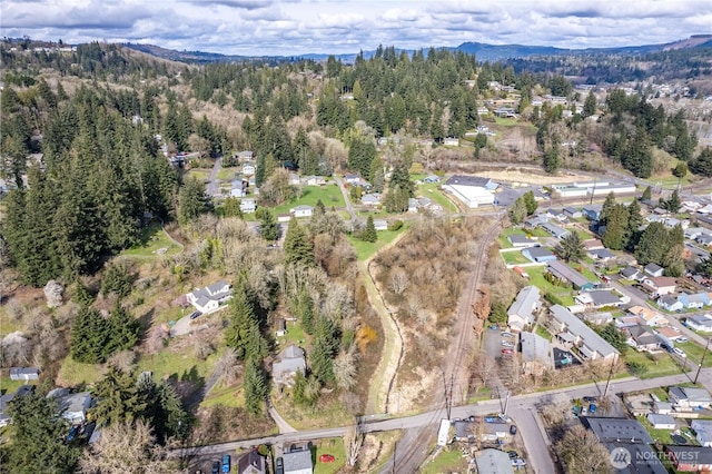 birds eye view of property with a mountain view and a view of trees