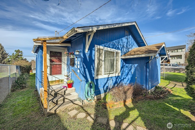 view of home's exterior with entry steps, a yard, and fence