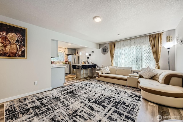 living room with light wood-type flooring and a textured ceiling