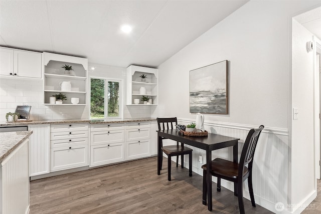 dining room with wainscoting, vaulted ceiling, and wood finished floors