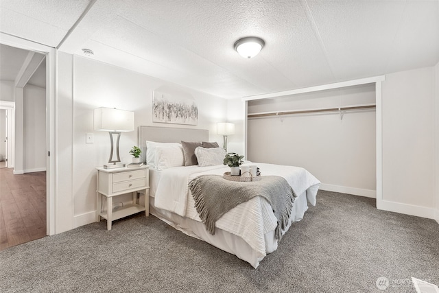 carpeted bedroom featuring a textured ceiling and baseboards