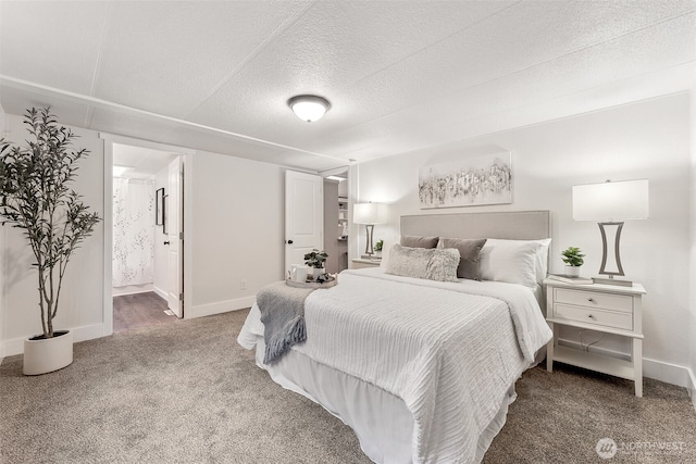 bedroom featuring a textured ceiling, carpet, connected bathroom, and baseboards