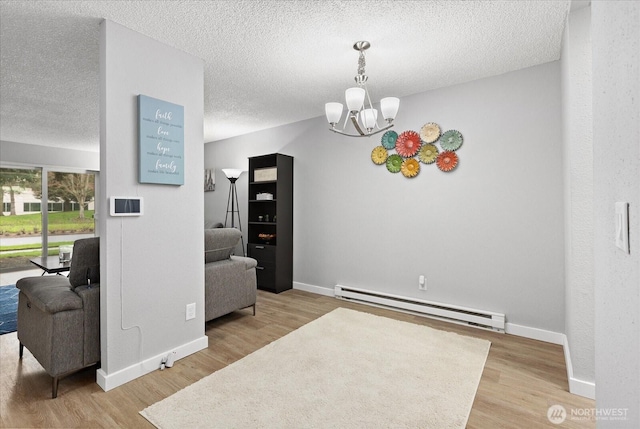 interior space with a notable chandelier, a baseboard radiator, a textured ceiling, and wood finished floors