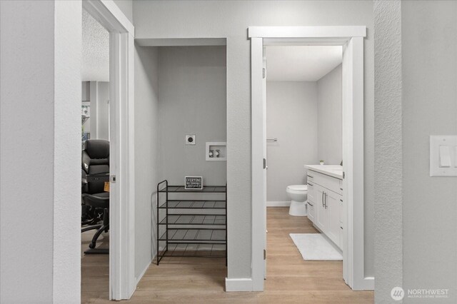 bathroom featuring toilet, wood finished floors, vanity, and baseboards