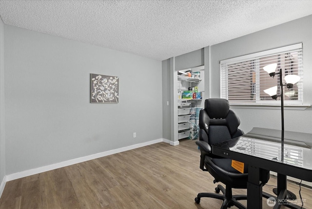 office space featuring a textured ceiling, baseboards, and wood finished floors