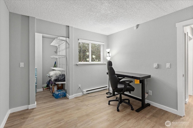 home office with baseboard heating, wood finished floors, and baseboards