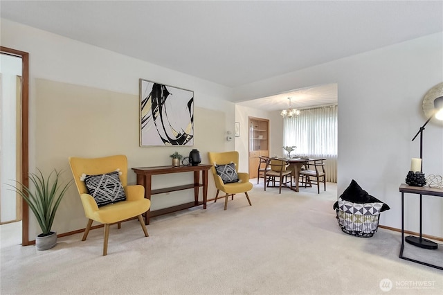 sitting room with an inviting chandelier, carpet, and baseboards