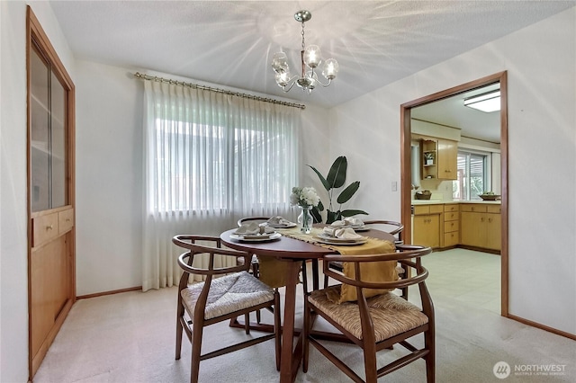 dining area with a notable chandelier, baseboards, and light carpet