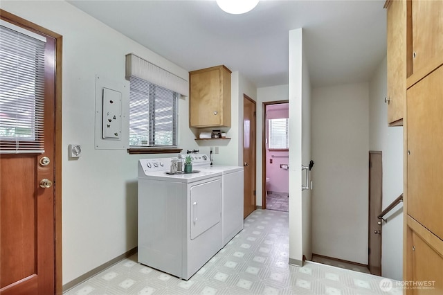 washroom featuring washer and dryer, baseboards, cabinet space, and light floors