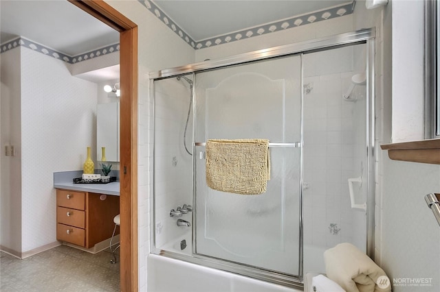 bathroom featuring tile patterned floors, toilet, wallpapered walls, bath / shower combo with glass door, and vanity