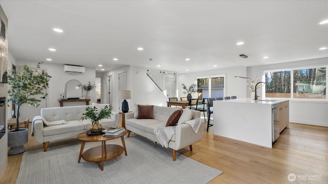 living area featuring light wood finished floors, recessed lighting, and an AC wall unit