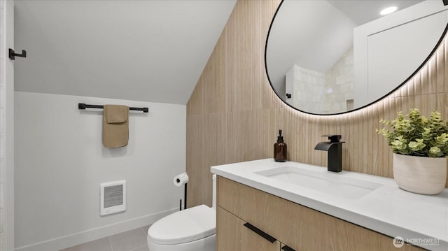 bathroom with visible vents, toilet, tile patterned flooring, lofted ceiling, and vanity