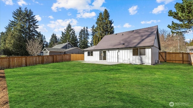 rear view of property with a fenced backyard, a lawn, board and batten siding, and a patio