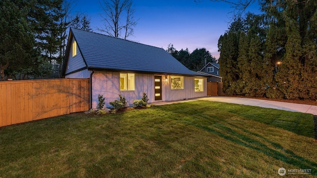 view of front of property with a patio area, a front lawn, and fence