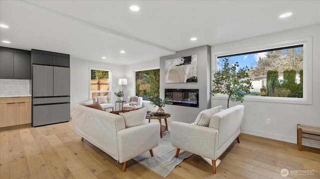 living area featuring recessed lighting, baseboards, and light wood finished floors