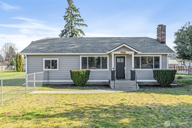 view of front of property featuring a chimney, a shingled roof, a front yard, and fence