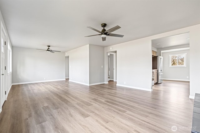 unfurnished living room with light wood-type flooring, baseboards, and a ceiling fan