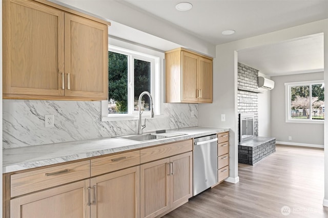 kitchen featuring light brown cabinetry, a sink, tasteful backsplash, a wall unit AC, and dishwasher