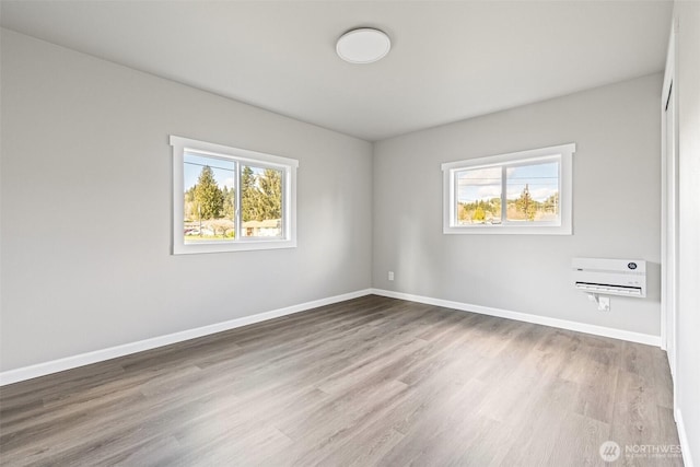 empty room featuring wood finished floors, a healthy amount of sunlight, and baseboards