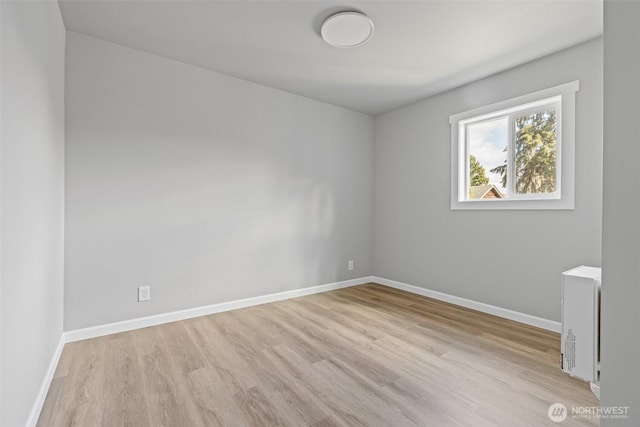 empty room featuring baseboards and wood finished floors