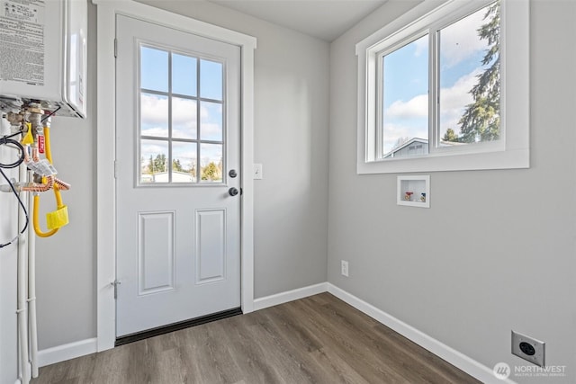 doorway featuring dark wood-style floors, baseboards, and water heater