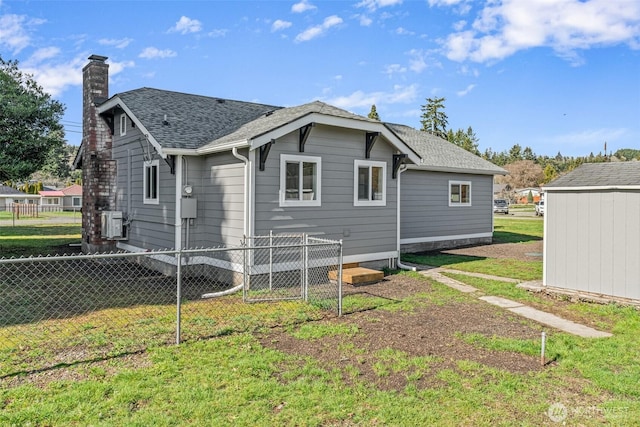 rear view of property featuring a lawn, a chimney, roof with shingles, and fence