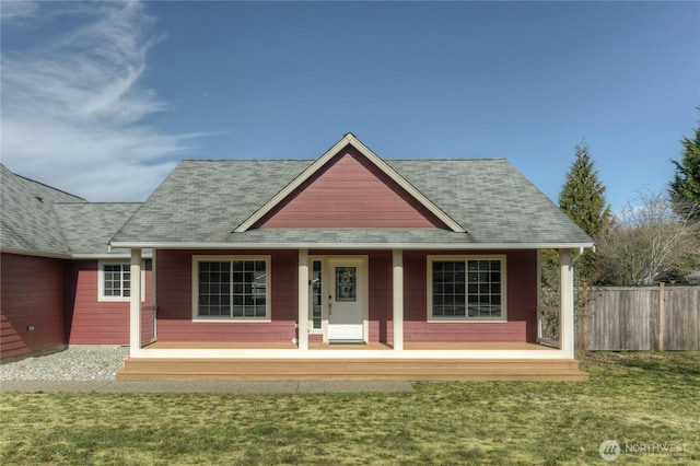 view of front of home with a shingled roof, a front yard, fence, and a porch