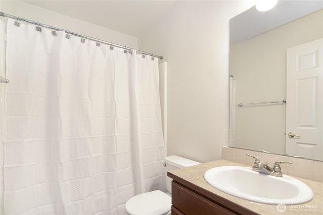 bathroom with curtained shower, vanity, and toilet