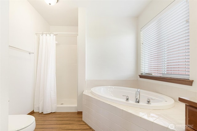 full bath featuring toilet, a stall shower, wood finished floors, and a bath