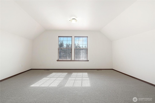 additional living space with carpet floors, lofted ceiling, and baseboards