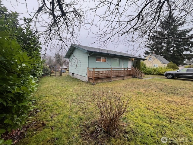 view of front of home featuring fence and a front lawn