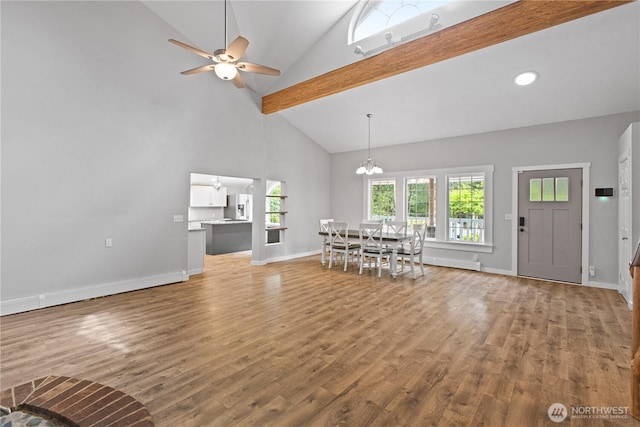 interior space with baseboards, wood finished floors, and ceiling fan with notable chandelier