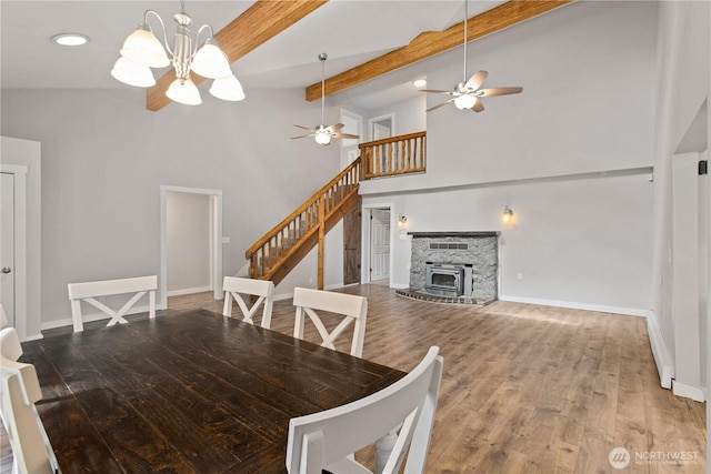 dining area with wood finished floors, baseboards, high vaulted ceiling, stairs, and beamed ceiling