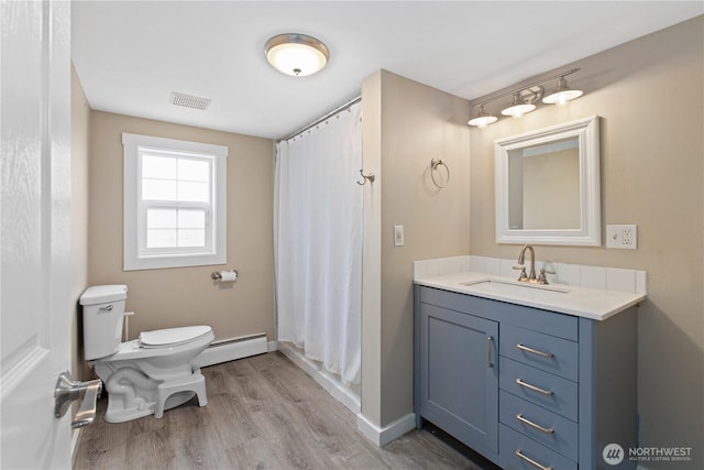 bathroom featuring visible vents, a baseboard heating unit, baseboards, toilet, and wood finished floors