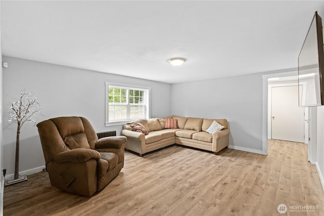 living room with light wood finished floors, radiator heating unit, and baseboards