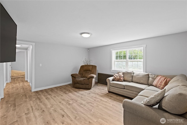 living room featuring light wood-style flooring, radiator, and baseboards