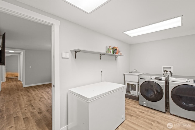 laundry room with light wood finished floors, laundry area, washer and dryer, and baseboards