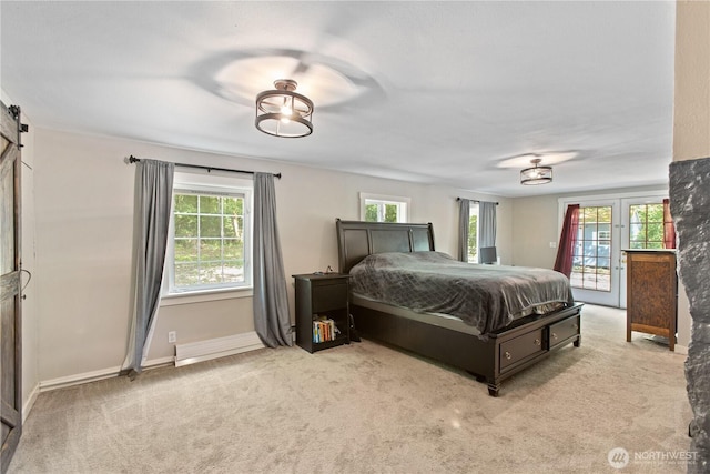 carpeted bedroom featuring a barn door, access to exterior, and baseboards