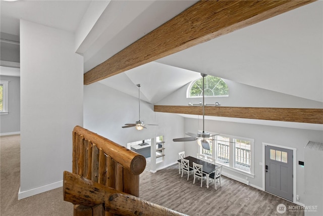 interior space featuring ceiling fan, baseboards, beamed ceiling, wood finished floors, and high vaulted ceiling