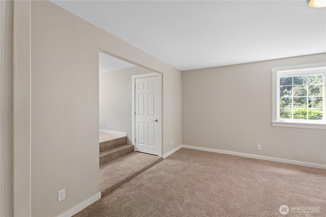 spare room with baseboards, carpet floors, and stairs