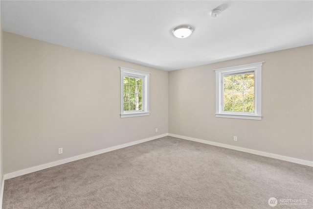 carpeted spare room with baseboards