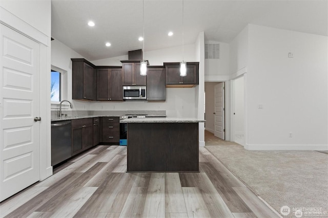 kitchen featuring visible vents, a kitchen island, hanging light fixtures, stainless steel appliances, and dark brown cabinets