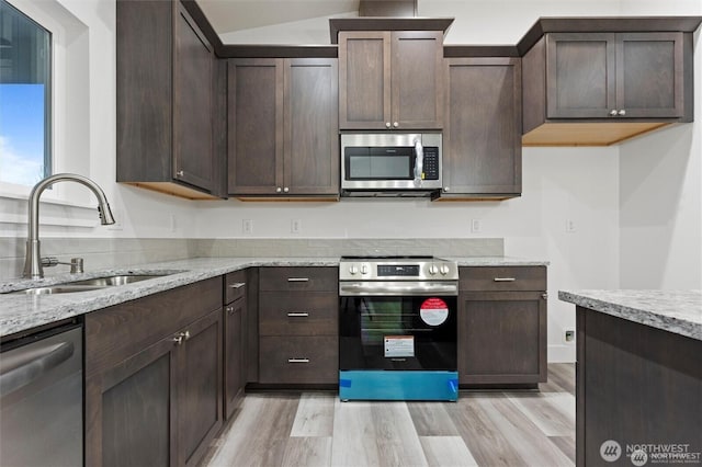 kitchen featuring stainless steel appliances, dark brown cabinets, and a sink