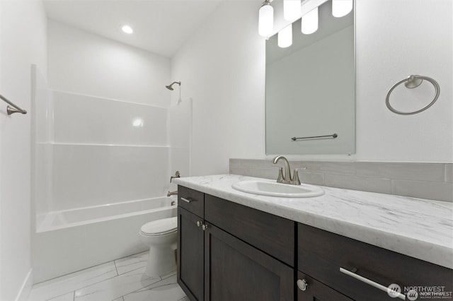 bathroom featuring toilet, marble finish floor, washtub / shower combination, and vanity