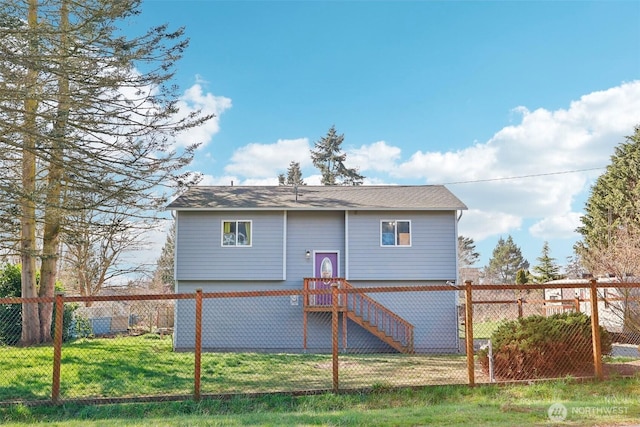 back of property with stairs, a yard, and a fenced backyard